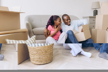 Smiling couple opening a cardboard box while moving into a new home, surrounded by belonging packeds