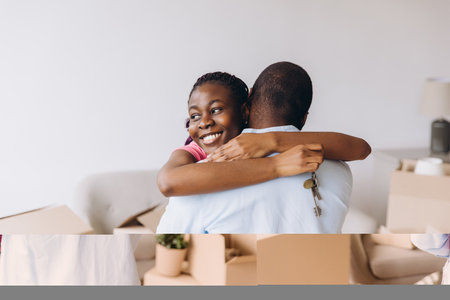 Young African American couple embracing joyfully after receiving keys to their new home, celebrating a significant milestone in their livesの写真素材