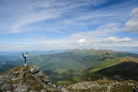 young woman practices yoga on a mountain top, Carpathian mountainsの写真素材
