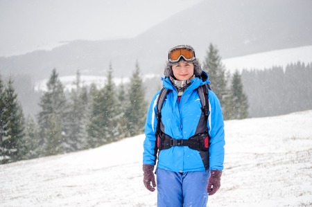 Portrait of beautiful girl on top of snow-covered mountains looking at cameraの写真素材