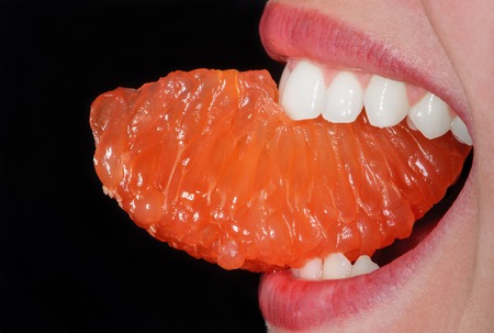 Close-up orange in the woman's mouth. Macroの写真素材