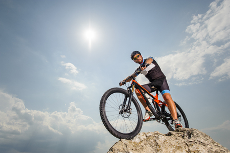the guy with the bike on top of the mountainの写真素材