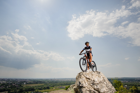 the guy with the bike on top of the mountainの写真素材