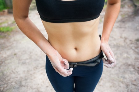 Close-up woman with nice waist hands with magnesium preparing climbingの写真素材