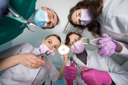 Professional dental team with removers. Bottom view. Focus on the tool. Medicine, dentistry and health care concept. Dental equipmentの写真素材