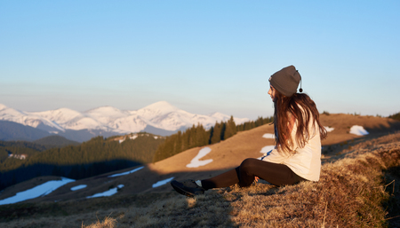 Shot of a woman admiring stunning view sitting on top of a mountain copyspace peace nature harmony lifestyle active sportive healthy relaxing resting meditativeの写真素材