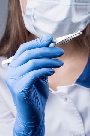 Close-up. Dentist holding reverse tweezers. Orthodontic treatment. Dentistryの写真素材