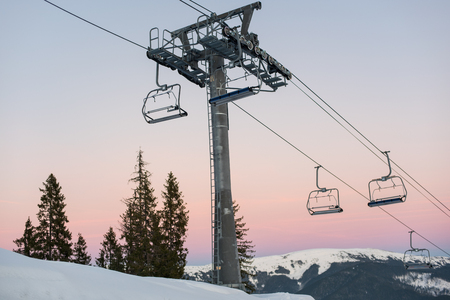 Ski lift chairs on winter resort against a beautiful sky at sunset. Carpathian Mountains, Bukovel, Ukraineの写真素材