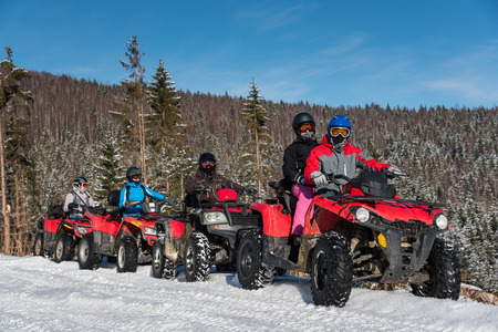 Group of people driving four-wheelers ATV bikes on snow in winterの写真素材