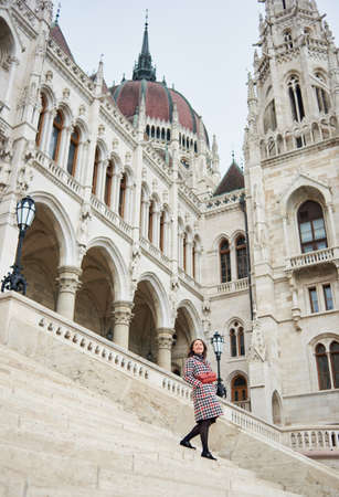Woman descends the steps of the architectural structure of the city of Budapest. Palace of Parliament in Budapest, Hungary. Photo from below. Autumnの写真素材