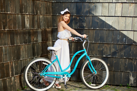 Attractive young happy woman walking with her bicycle outdoors copyspace smiling positivity happiness emotions expressive riding cyclist.の写真素材
