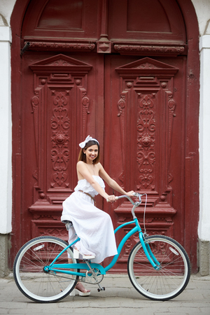 Vertical shot of a joyful young woman resting near an old building in the city center holding her bicycle after cycling urban lifestyle active people happiness youth travel.の写真素材