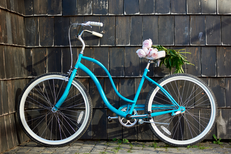 Shot of a blue city bicycle near the wall with a bunch of pink peonies on the seat copyspace flowers love romance romantic travelling memories tourism love transportation lifestyle.の写真素材