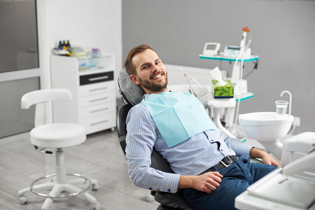 Portrait of happy patient in dental chair. Modern dentistry with the use of new technologiesの写真素材
