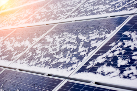 Alternative electricity source. Photovoltaic solar panels covered with snow on top of modern house....