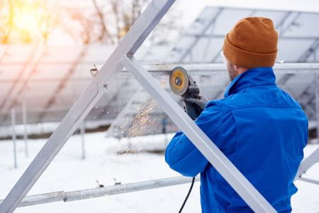 Rearview shot of a professional electricity technician installing solar panels outdoors in winter copyspace alternative energy green friendly environmental source profession occupation photovoltaic.の写真素材