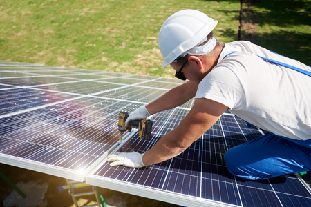 Concentrated mounter installing innovative solar panels. High-tech exterior, modern equipment, ecological frienly, green energy. Electricity saving, using renewable energy of sun. Smart building.の写真素材