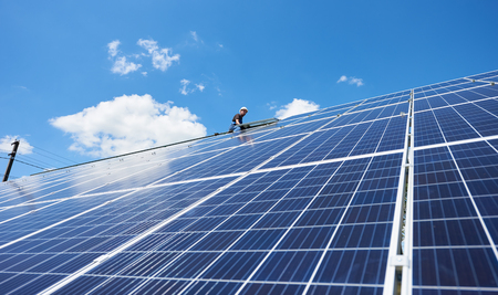 Innovative solar batteries screen on blue sky background. High-tech exterior, modern equipment, ecological frienly, green energy. Electricity saving, using renewable energy of sun. New solution.の写真素材