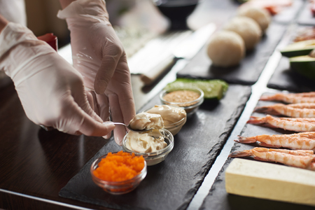 Closeup of chef hands preparing japanese food. Japanese chef making sushi rolls at restaurant.の写真素材