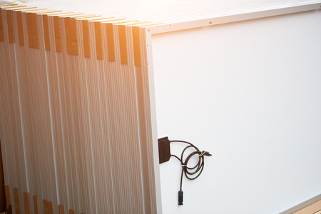 Close-up of new shiny white solar photo voltaic panel modules set ready for buying, transportation and installation. Renewable eco-friendly green energy production concept. Copy space background.の写真素材