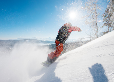 Freerider snowboarder riding the slope on a sunny winter day in the mountains copyspace snowboarding active lifestyle sports recreation resort. Snow in the airの写真素材