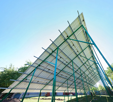 Green metallic carcass maintaining solar batteries. smart exterior, using renewable sun energy. Ecological friendly, nature saving, economical. Innovative high-tech technologies. Renewable resources.の写真素材