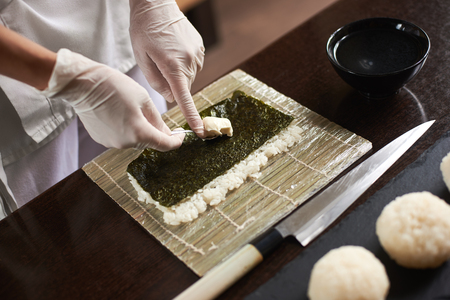 Close-up of chef hands preparing japanese food. Japanese chef making sushi at restaurant.の写真素材