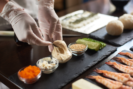 Close-up of chef hands preparing japanese food. Japanese chef making sushi rolls at restaurant.の写真素材