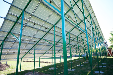 Green metallic carcass maintaining solar batteries. smart exterior, using renewable sun energy. Ecological friendly, nature saving, economical. Innovative high-tech technologies. Renewable resources.の写真素材
