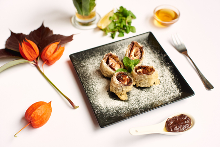 Food flat lay with plants on white tablecloth. Noodles with meet in center decorated with seeds, red and yellow peppers, soya sous and zucchini. Food and vegetable concept.の写真素材