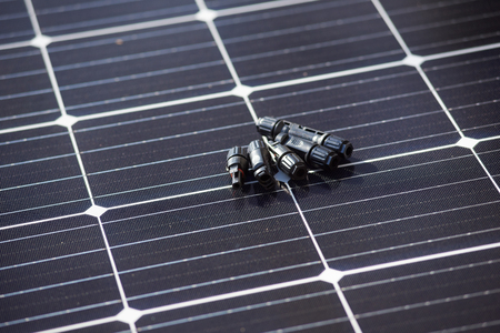 Close-up view of details for installing and connecting solar photovoltaic system. Objects laying on blue solar panelの写真素材