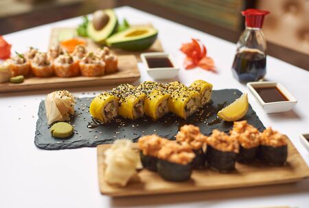 Tasty and delicious lunch from three courses in luxury Japanese restaurant. Gourmet set from sushi rolls served with soy sauce, wasabi and marinated ginger. Oriental meal made from rice and seafood.の写真素材