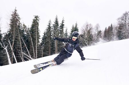 Skiing down from high slope. Professional skier during training making unlucky maneuver on turning...