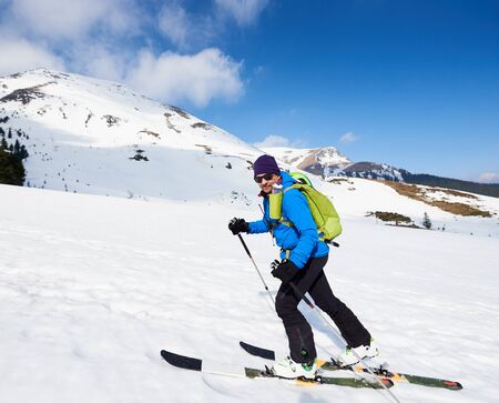 Ski touring man ascending during ski touring in the spectacularly white mountains. Snow and winter activities, skitouring in mountains.の写真素材