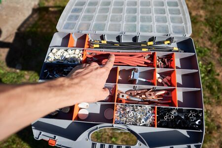 Photo of worker's hand choosing detail from big opened case needing by exterior technology solar...