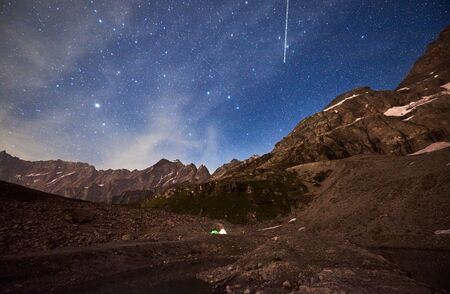 Magic scenery at night with blue sky and shining stars, beautiful mountains area with snow. Gorgeous...