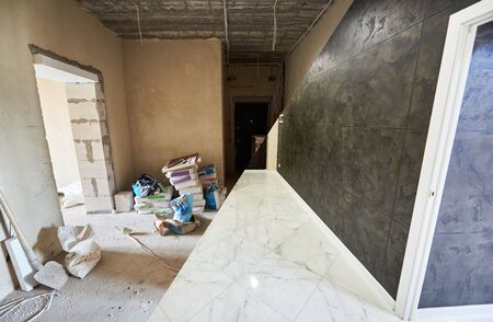 Messy dirty room at the beginning of reconstruction works vs clean shiny tiled part of a new room, white floor and black wall, renovation conceptの写真素材