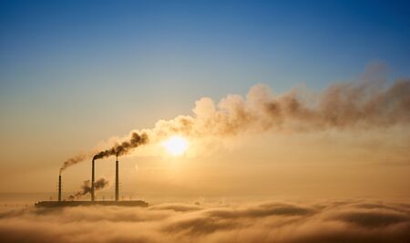 Stunning view of thermoelectric power plant with dense smoke and blue sky on background. Huge amount...