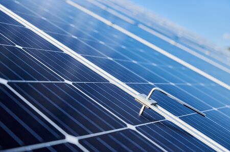 Close-up snapshot of a new blue shiny solar module and a hex key stuck in between. Green energy concept. Modern technologies, ecological solution, power sustainable resources conceptの写真素材