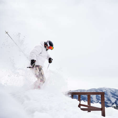 Winter kinds of sport concept. Skier wearing winter sports costume and ski equipment doing jumping...
