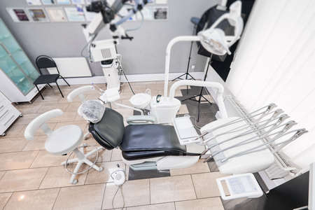 Snapshot of empty clean dental office. Top view on dental chair and stomatological equipment for teeth treatment. Interior of modern dental clinicの写真素材