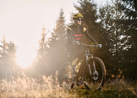 Male cyclist riding mountain bicycle on sunny day.