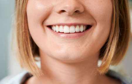Cropped snapshot of a beautiful female smile demonstrating perfect teeth.の写真素材