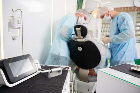 Dentists using dental implant machine in modern dental office.の写真素材