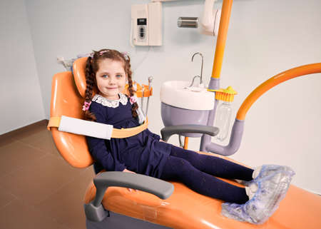 Adorable little girl sitting in dental chair.の写真素材