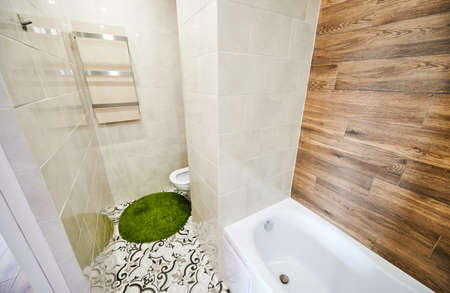 View of left part of small light bathroom with modern renovation. White tiles on the walls combining...