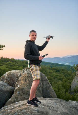 Man operating drone using remote controller. Man using drone at sunset for photos and video making...
