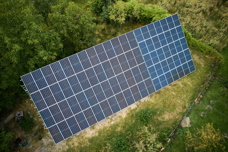 Aerial view of solar panels in green field at daytime. Different types of ground-mounted...