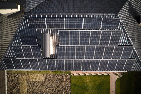 Residential house with solar photovoltaic panel system on rooftop. Building roof with solar modules...