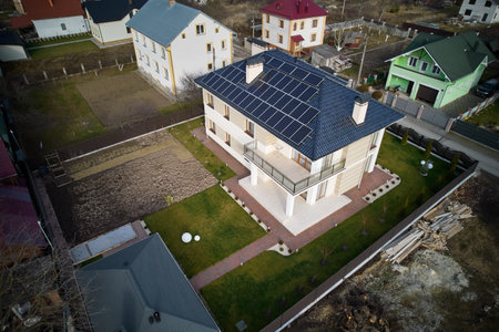 Aerial drone view of autonomous house with photovoltaic solar panels on rooftop. Home with solar modules for generating electricity through photovoltaic effect.の写真素材
